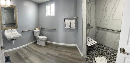 a bathroom with a toilet and a sink and a shower at Sea Garden Inn in Pismo Beach