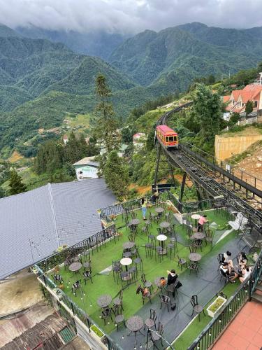 a train on a bridge with people sitting at tables at SaPa Retreat Condotel in Sa Pa