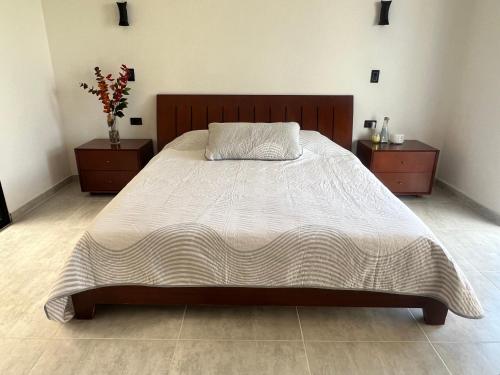 a bedroom with a large bed with two night stands at Alojamiento en Pereira suite Soret tipo Glamping in Dosquebradas