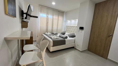 Un dormitorio con una cama y una mesa y sillas. en Aptos y Apartaestudios frente al Malecón y el Embalse, Zona Gastronómica, a 8 minutos de la Piedra del Peñol, TODO CERCA!!!, en Guatapé