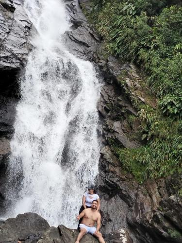 two men sitting on rocks in front of a waterfall at Sierra de viboral adventures in Medellín