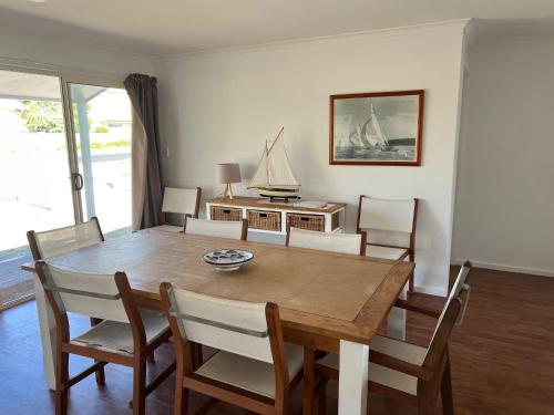 a dining room with a wooden table and chairs at Elandra House - WiFi pet friendly outside in Robe