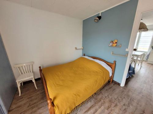 une chambre avec un lit avec une couverture jaune dans l'établissement Appartement cosy 4 pers avec balcons à 2 min de la plage - FR-1-672-36, à Merlimont
