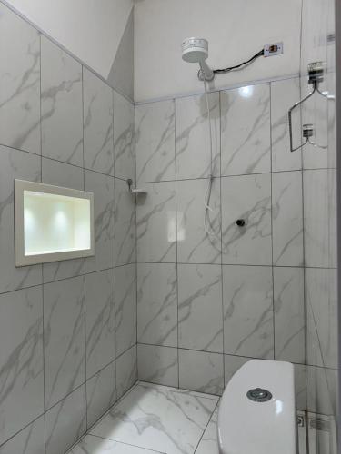 a bathroom with a shower and a toilet at Pousada B&B - na cidade Capivari-SP in Capivari