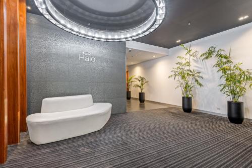 a white toilet in a lobby with potted plants at Complete Host Halo Apartments in Melbourne