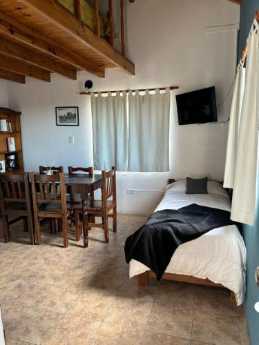 a bedroom with a bed and a dining room at Apart Haiken in El Calafate