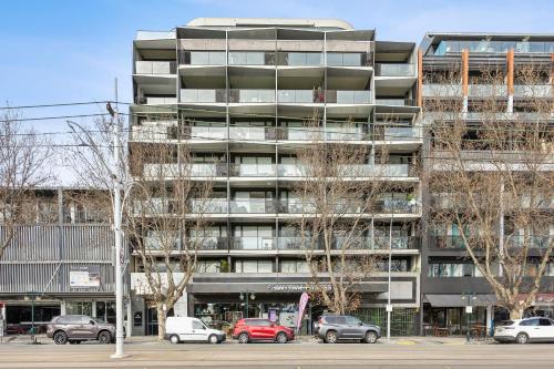 a tall building with cars parked in front of it at Complete Host Halo Apartments in Melbourne