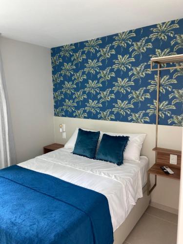 a bedroom with blue walls and a bed with blue pillows at Sunny Hall - Porto de Galinhas in Porto De Galinhas