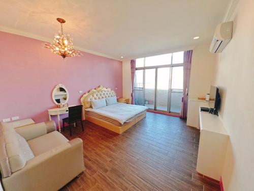 a bedroom with a bed and a couch and a tv at 台南樂河民宿 in Tainan
