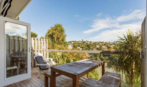 a patio with a wooden table and chairs on a balcony at Kelburn House at the top of the Cable Car in Wellington