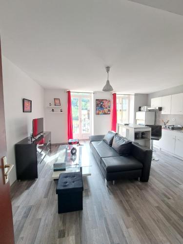un salon avec un canapé et une table dans l'établissement Joli appartement meublé refait à neuf, à Argis
