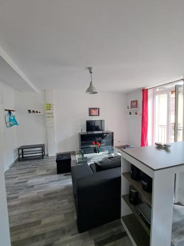 un salon avec un canapé et une table dans l'établissement Joli appartement meublé refait à neuf, à Argis