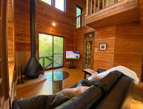 a living room with a couch and a tv at 花の街662#Private villa in Azumaiokozan
