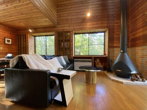 a living room with a couch and a fireplace at 花の街662#Private villa in Azumaiokozan