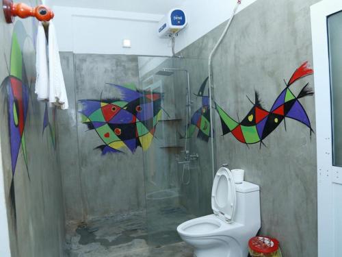 a bathroom with a shower with colorful kites on the wall at Phong Nha Midtown Hotel in Phong Nha