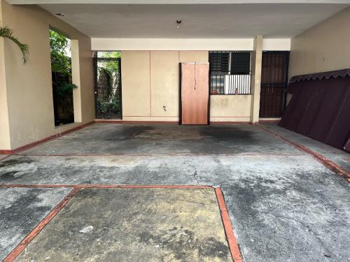an empty parking lot with a door in a building at Private House with Pool, AC, BBQ, Fast Wi-Fi, Pet & Family Friendly, Near Colonial Zone, Mirador Sur Park & Ocean, in Santo Domingo in Santo Domingo