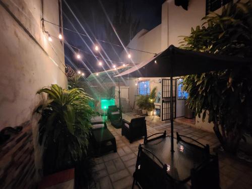 a patio with an umbrella and plants and lights at Private House with Pool, AC, BBQ, Fast Wi-Fi, Pet & Family Friendly, Near Colonial Zone, Mirador Sur Park & Ocean, in Santo Domingo in Santo Domingo
