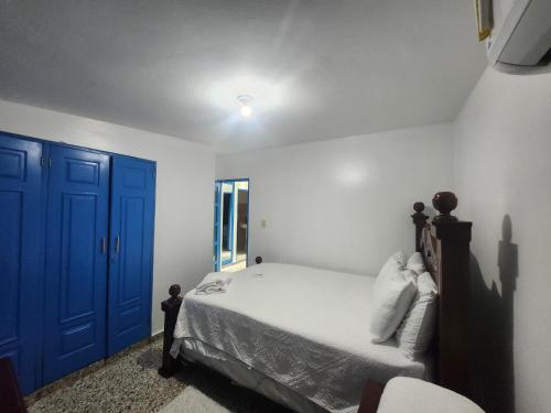 a bedroom with a bed with a blue door at Private House with Pool, AC, BBQ, Fast Wi-Fi, Pet & Family Friendly, Near Colonial Zone, Mirador Sur Park & Ocean, in Santo Domingo in Santo Domingo