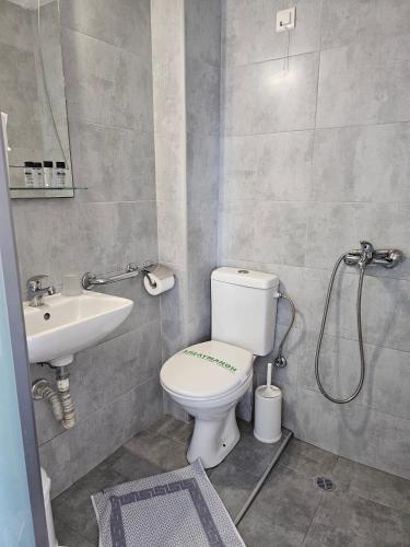 a bathroom with a toilet and a sink at Nisaki Hotel & Elite Suites in Ermoupoli