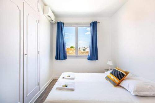 - une chambre avec un lit doté de rideaux bleus et d'une fenêtre dans l'établissement La Girafe Rouge, à Bègles