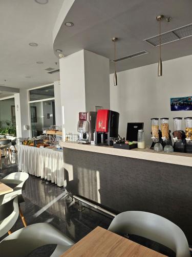 a restaurant with a bar with chairs and a counter top at Nisaki Hotel & Elite Suites in Ermoupoli
