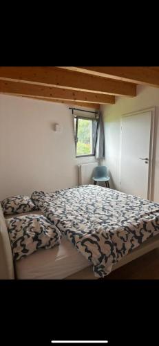 une chambre avec un lit avec une couette et une fenêtre dans l'établissement Logement route de vin, à Bœrsch