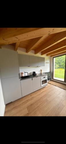 une cuisine avec des appareils blancs et un parquet dans l'établissement Logement route de vin, à Bœrsch