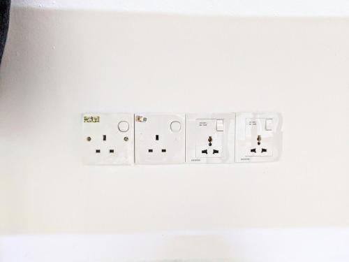 a white light switch on a white wall at Private Room with Bathroom in Kuala Lumpur