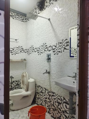 a bathroom with a toilet and a sink at geo gardens residency in Alwaye