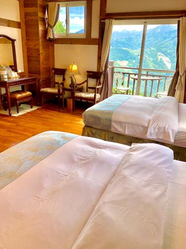 a hotel room with two beds and a balcony at The Cotswolds Villa in Renai