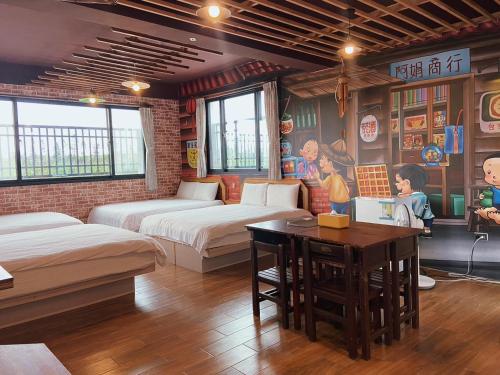 una camera con due letti e un tavolo di Big Fish Homestay a Magong