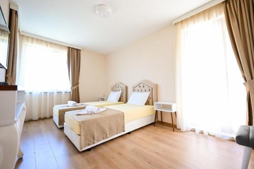 a hotel room with two beds and windows at Kristin Palace in Obzor