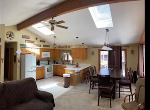 a kitchen and living room with a table and a ceiling fan at The Great Escape of Arrowhead in Thornhurst