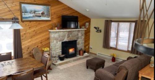 a living room with a fireplace and a table and chairs at The Great Escape of Arrowhead in Thornhurst