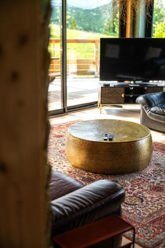 un salon avec une grande table basse ronde dans l'établissement Poli Resort, calme et haut-de-gamme au sommet, à Xonrupt-Longemer