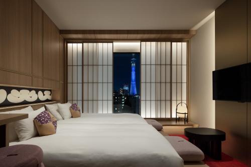 a bedroom with a large bed and a large window at OMO3 Asakusa by Hoshino Resorts in Tokyo