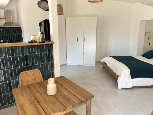 une chambre avec un lit et une table en bois dans l'établissement Un petit coin de paradis - Studio Pura Vida, à 200m de la plage dans une calanque préservée, à Ensuès-la-Redonne