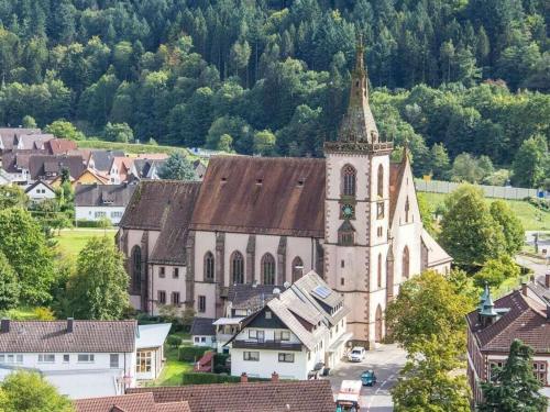 an old church with a steeple in a small town at Ferienhof Mayer - Apartment 2 in Lautenbach