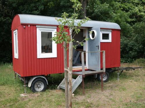 a red and white tiny house sitting in a field at Gutshaus Ganzlin Comfortable holiday residence in Ganzlin