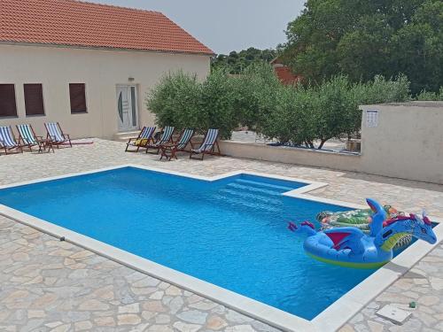 a child in an inflatable raft in a swimming pool at Kuća za odmor Mira blizu Biograda na moru in Donja Jagodnja