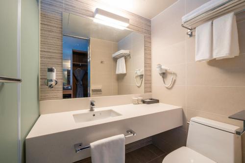 a bathroom with a sink and a toilet and a mirror at Homes Stay Suwon in Suwon