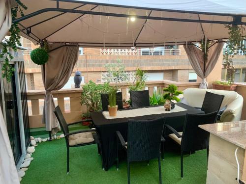 a table and chairs under an umbrella on a patio at RuMar apartamento con terraza in Alicante