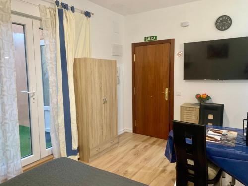 a living room with a table and a television and a door at RuMar apartamento con terraza in Alicante