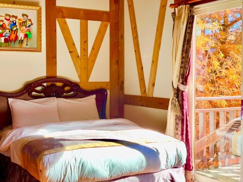 a bedroom with a bed and a window at The Cotswolds Villa in Renai
