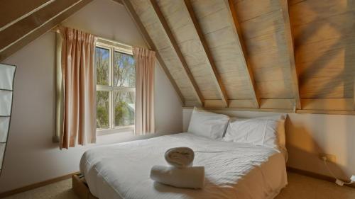 a bedroom with a bed with a wooden head on it at Pinnacle in Dinner Plain