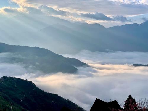 a view of a valley of clouds in the mountains at The Cotswolds Villa in Renai
