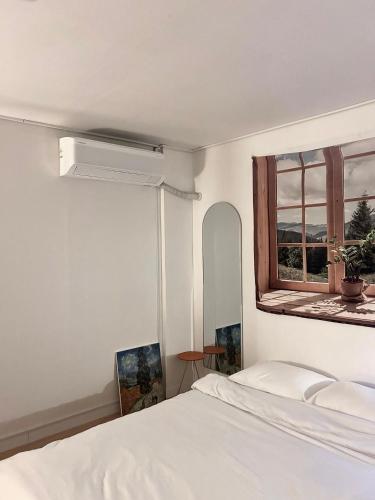 a bedroom with a white bed and a window at Momo House2 in Gimhae