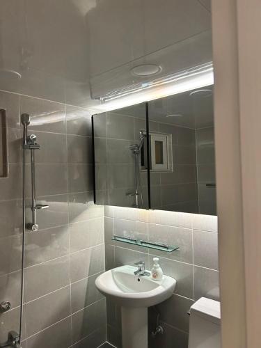 a bathroom with a sink and a shower and a mirror at Momo House2 in Gimhae