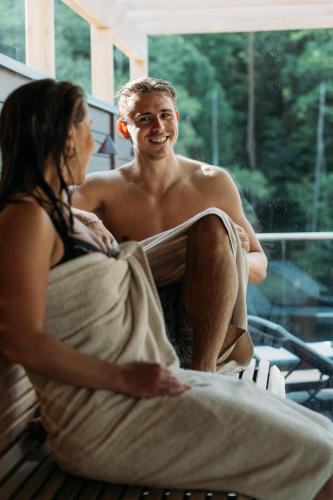 a woman is talking to a man in a tub at Hestraviken Hotell & Spa in Hestra