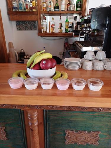 a bowl of fruit sitting on a table with bowls of food at Siroco's Rooms And Studios in Parikia